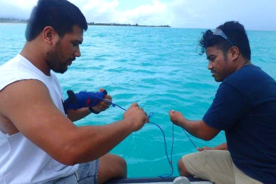 two people gathering water samples on boat