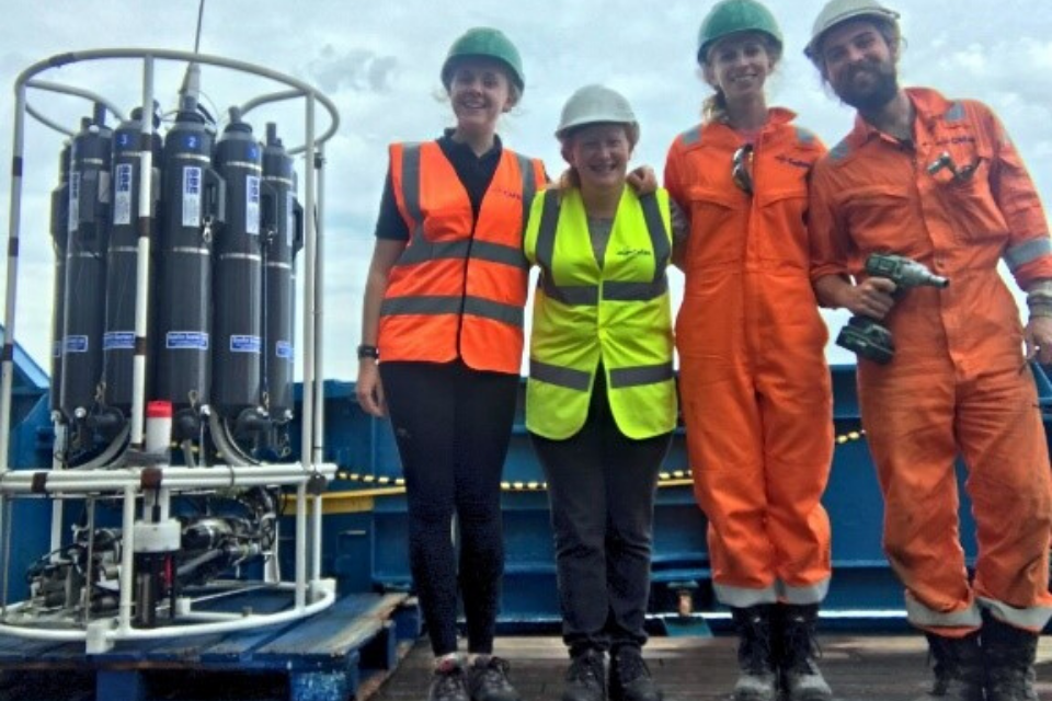 4 people on deck of boat by science equipment