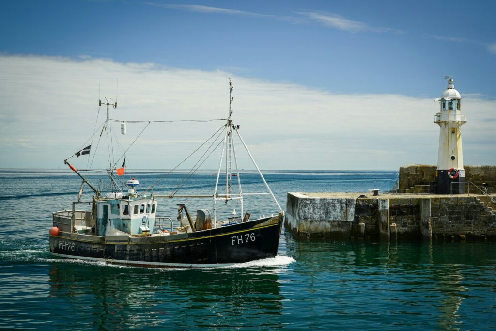 A Cornish fishing trawler entering the harbour in Mevagissey, Cornwall