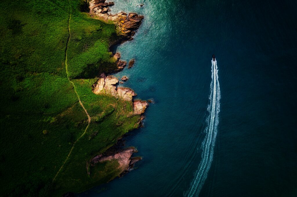 A power boat rocketing past the rock stacks along the Jurassic Coast,