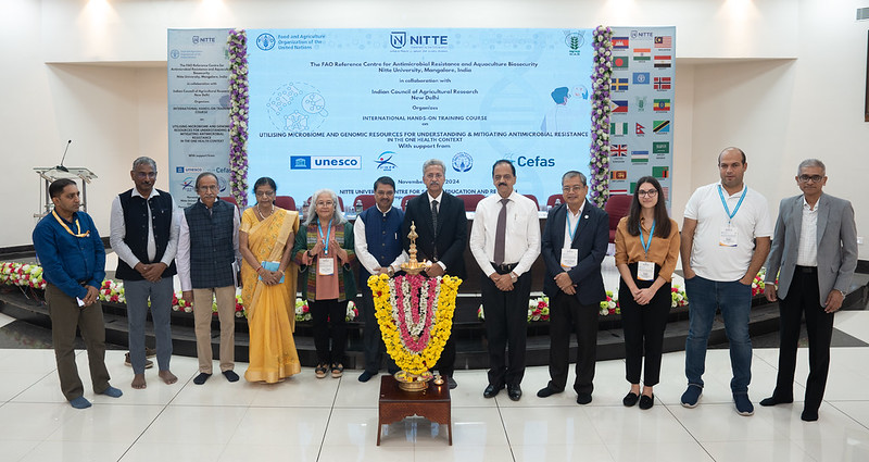 A group of people in India standing in front of a presentation